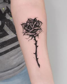 a black and white rose tattoo on the arm