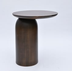 a round wooden table sitting on top of a white floor