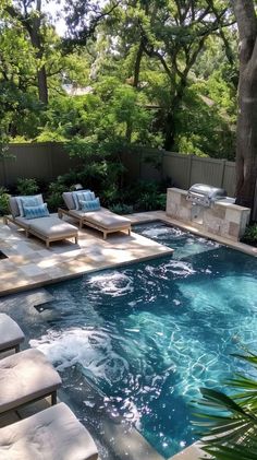 an outdoor swimming pool with lounge chairs and fire pit in the middle, surrounded by trees