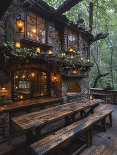 a wooden bench sitting in front of a building with lights on it's windows