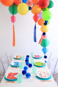 the table is set with colorful paper lanterns and plates for an understated party