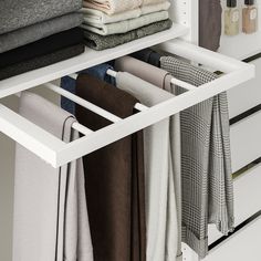 an organized closet with folded and unbuttoned clothes