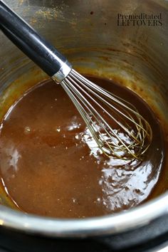 a whisk in a pot filled with brown liquid