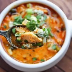 a spoon full of soup on top of a wooden table