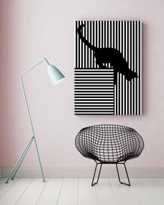 a black and white painting hanging on the wall next to a chair with a lamp