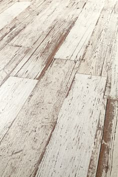 an old wooden floor with white paint and wood grains on the bottom part of it