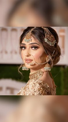 a woman in a gold dress with pearls on her head and jewelry around her neck