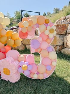 balloons are arranged in the shape of the number 5 and balloon bouquets for an outdoor birthday party