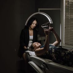 a woman sitting on top of a chair next to a window