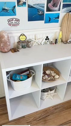 there is a shelf with various items on it and pictures above the shelves in the room