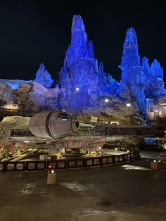 the star wars land is lit up at night