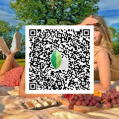 a woman laying on top of a blanket holding up a qr code for food