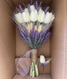 a bouquet of white and purple flowers in a cardboard box