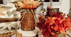 two decorative vases sitting on top of a table next to each other with flowers in them