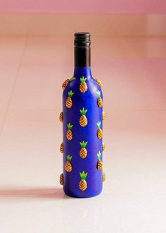 a blue bottle with pineapples painted on it