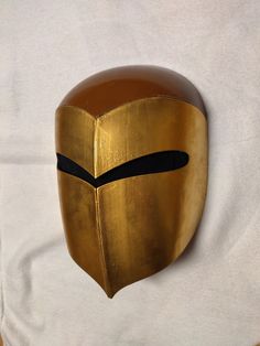 a gold mask with black lines on it