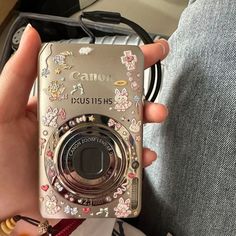 a person holding a camera in their hand with flowers and butterflies on the front cover