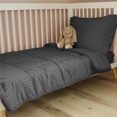 a teddy bear sitting on top of a bed next to a wooden headboard and pillow