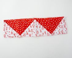 a red and white piece of fabric with two triangles on it