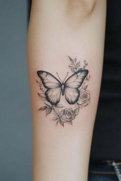 a woman's arm with a butterfly and roses tattoo on the left side of her arm