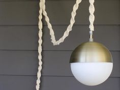 a light that is hanging from the side of a house with rope around it and two lights on each side