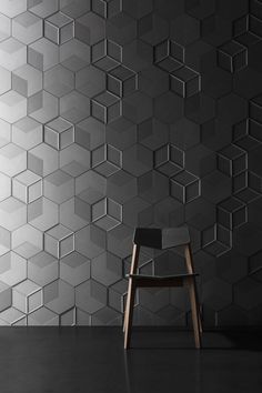 a chair sitting in front of a wall with hexagonal tiles on the walls