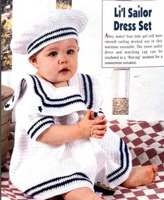 a baby dressed in a sailor's outfit sitting on a checkered table cloth