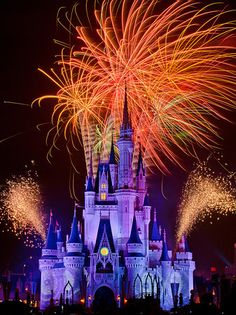 the castle is lit up with fireworks in front of it