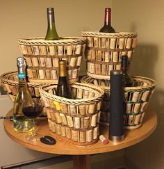 several wine bottles are sitting in baskets on a table