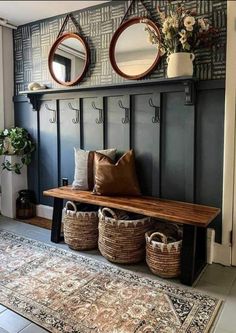 a bench with some baskets on it and two mirrors above the bench, along with other items