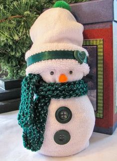 a snowman made out of knitted material with a green hat and scarf around his neck