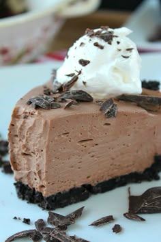 a piece of chocolate cream cheese pie on a plate with whipped cream and chocolate shavings