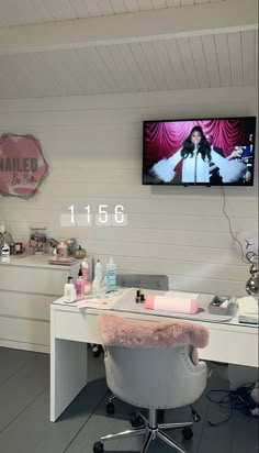 a white desk with a tv on top of it and pink fur rug in front of it