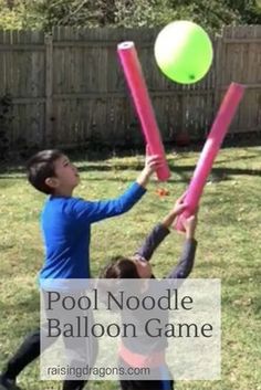 two children playing with pool noodle balloon game in the back yard on a sunny day