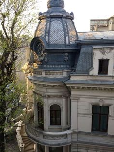 an old building with a clock on the top of it's roof and balcony