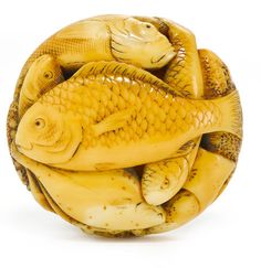 a yellow ceramic fish sculpture sitting on top of it's back legs in front of a white background