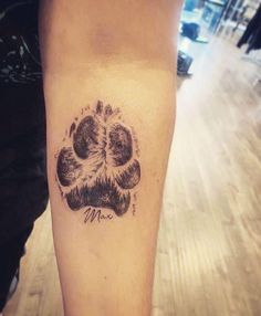 a black and white photo of a dog paw tattoo