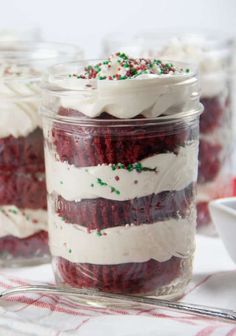 red velvet cake in a jar with white frosting and sprinkles on top