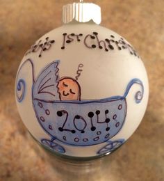 a glass ornament with a baby in a stroller on it's side