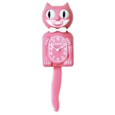 a pink clock with a cat face on it's face is shown in front of a white background