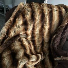 a brown and black fur blanket sitting on top of a couch