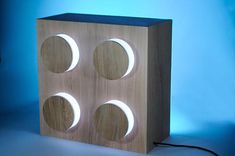 a wooden block with three moon phases on the front and sides, against a blue background