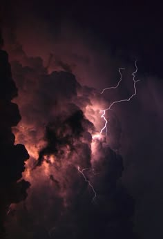 lightning strikes through the dark clouds in the night sky