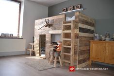 a loft bed made out of wooden pallets in a room with a deer head mounted on the wall