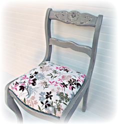 an old chair with a flowered seat cushion