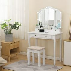 a white vanity table with stool and mirror