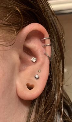 a woman with three piercings on her ear