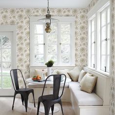 a dining room with white walls and black chairs