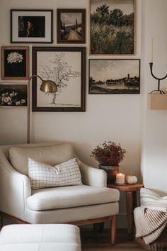 a living room with pictures on the wall and a chair next to a table in front of it