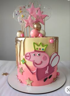 a peppa pig birthday cake with stars and decorations on the top is decorated in pink and gold